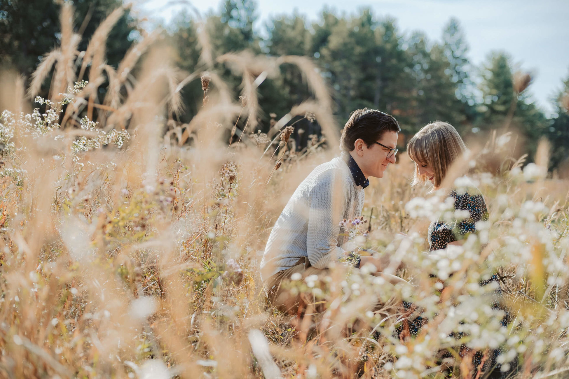 Fall Engagement Session in the Poconos with couple kneeling in wild flower feilds