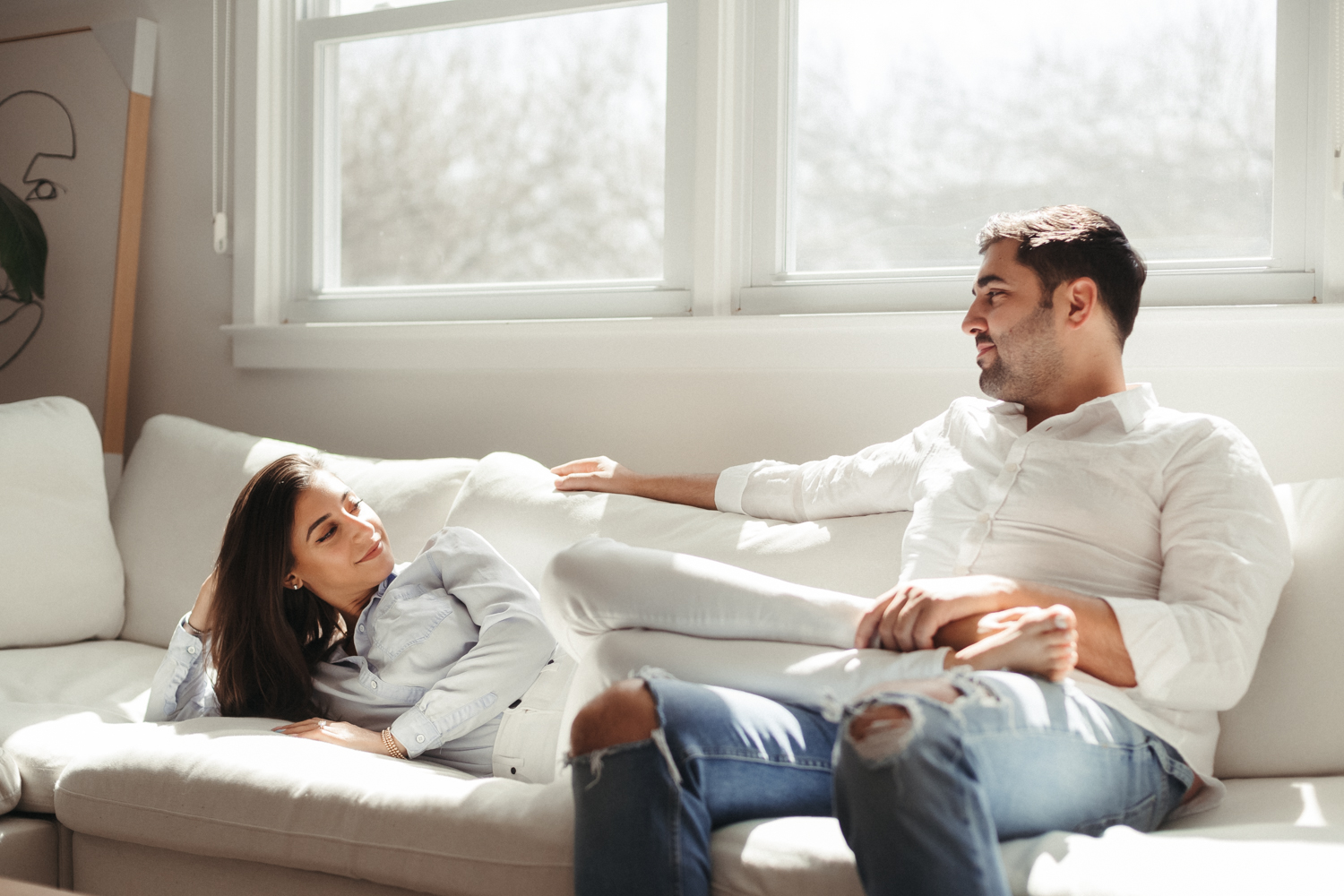 Couple lounges in their living room in this in-home family shoot