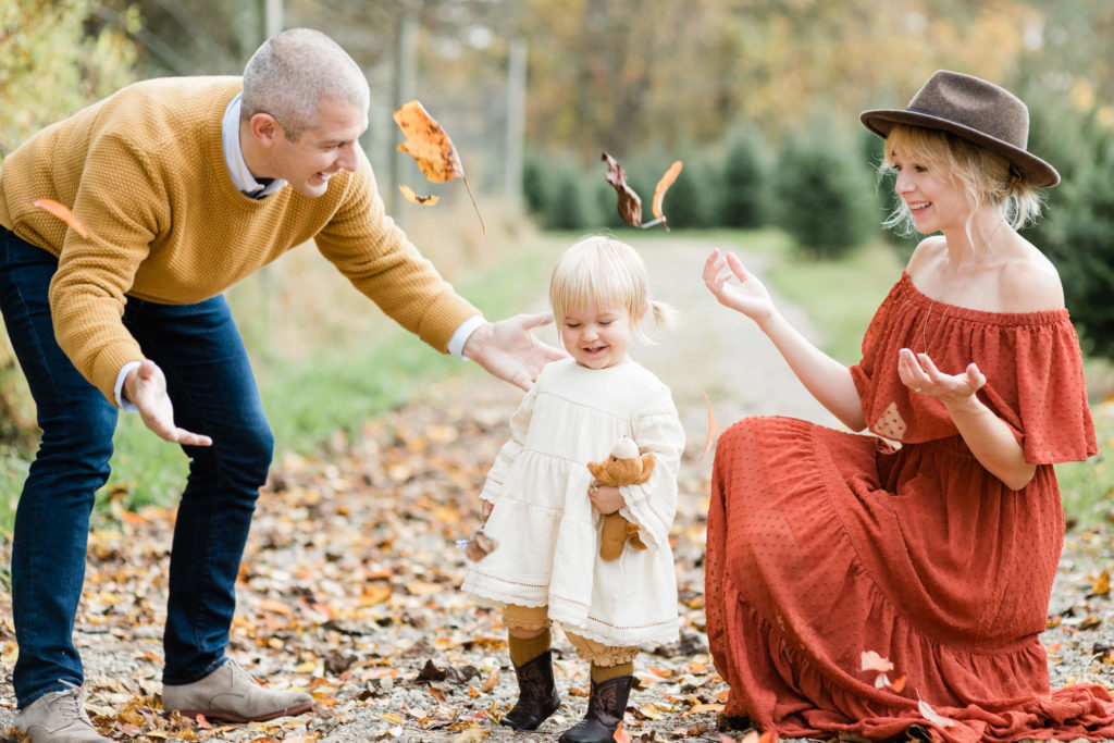 Philly family throwing leaved in the air at a Christmas Tree farm during their family session