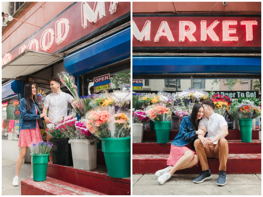 The couple looks at flowers for sale on the sidewalk during engagement photos in Philadelphia
