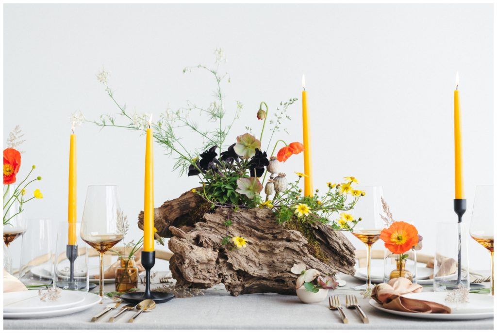 A log vase holds wedding flowers