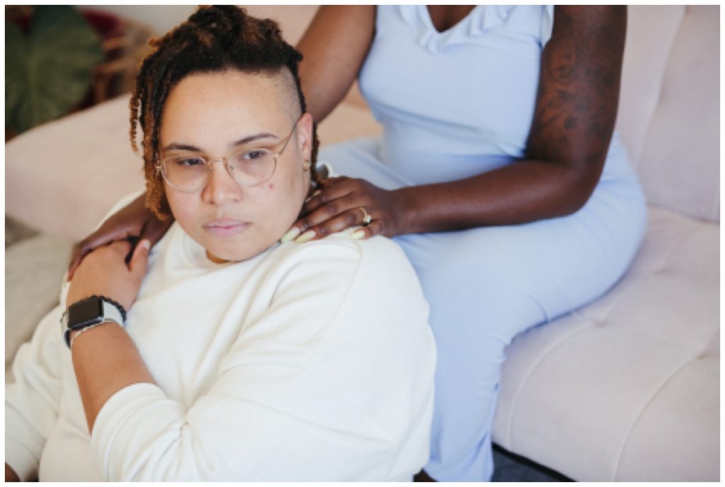 Nonbinary couple holds hands for in home photography session