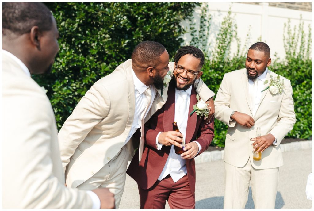 Groosmen laughs with groom in wedding photography in philadelphia