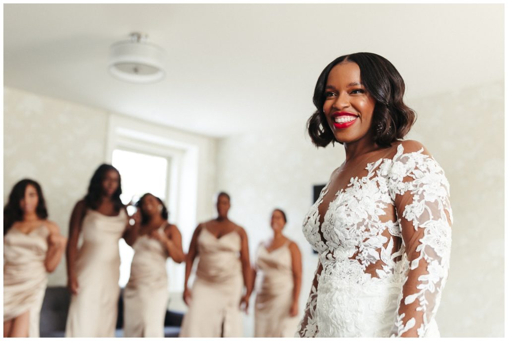 Bride smiles with bridesmaids behind her in wedding photography in philadelphia