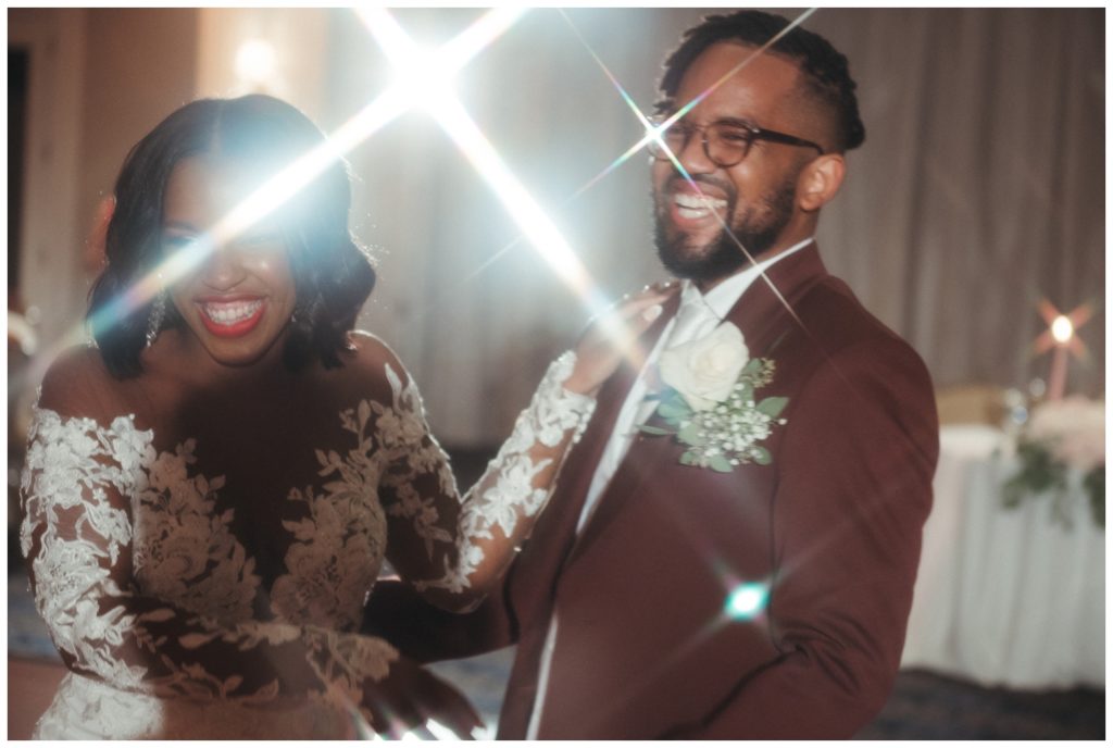 The couple laughs on the dance floor in wedding photography in philadelphia