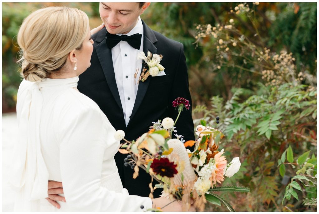 The groom puts his hand on his bride's back before their nontraditional wedding at Location 215