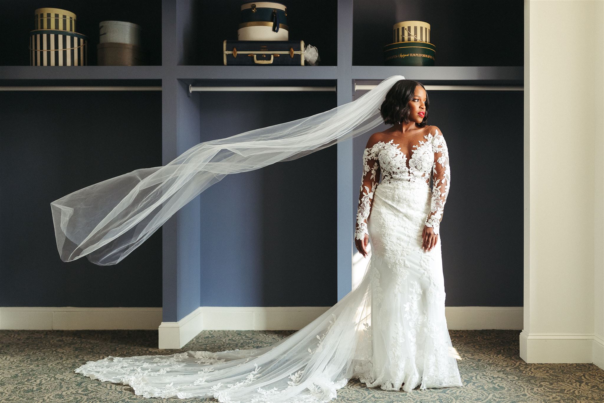 Bride looking stunning as she stares off into the distance with her sheer veil in the air, photographed by Jason Moody