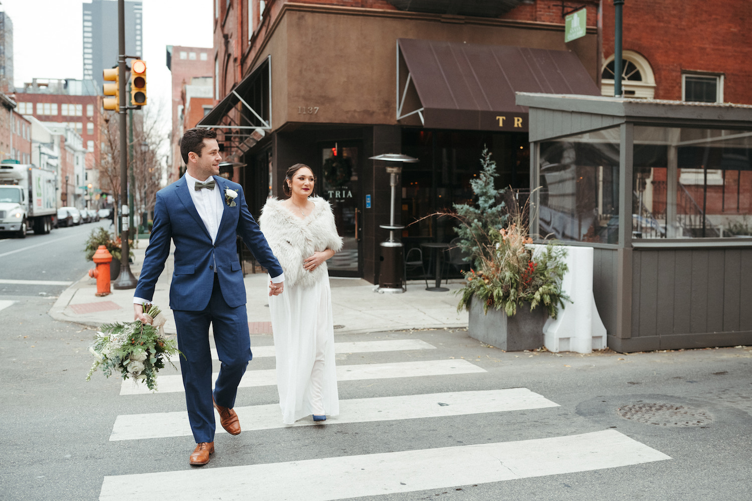 Bride and groom holding hands crossing the street during their solstice wedding at Vaux Studio by Jason Moody