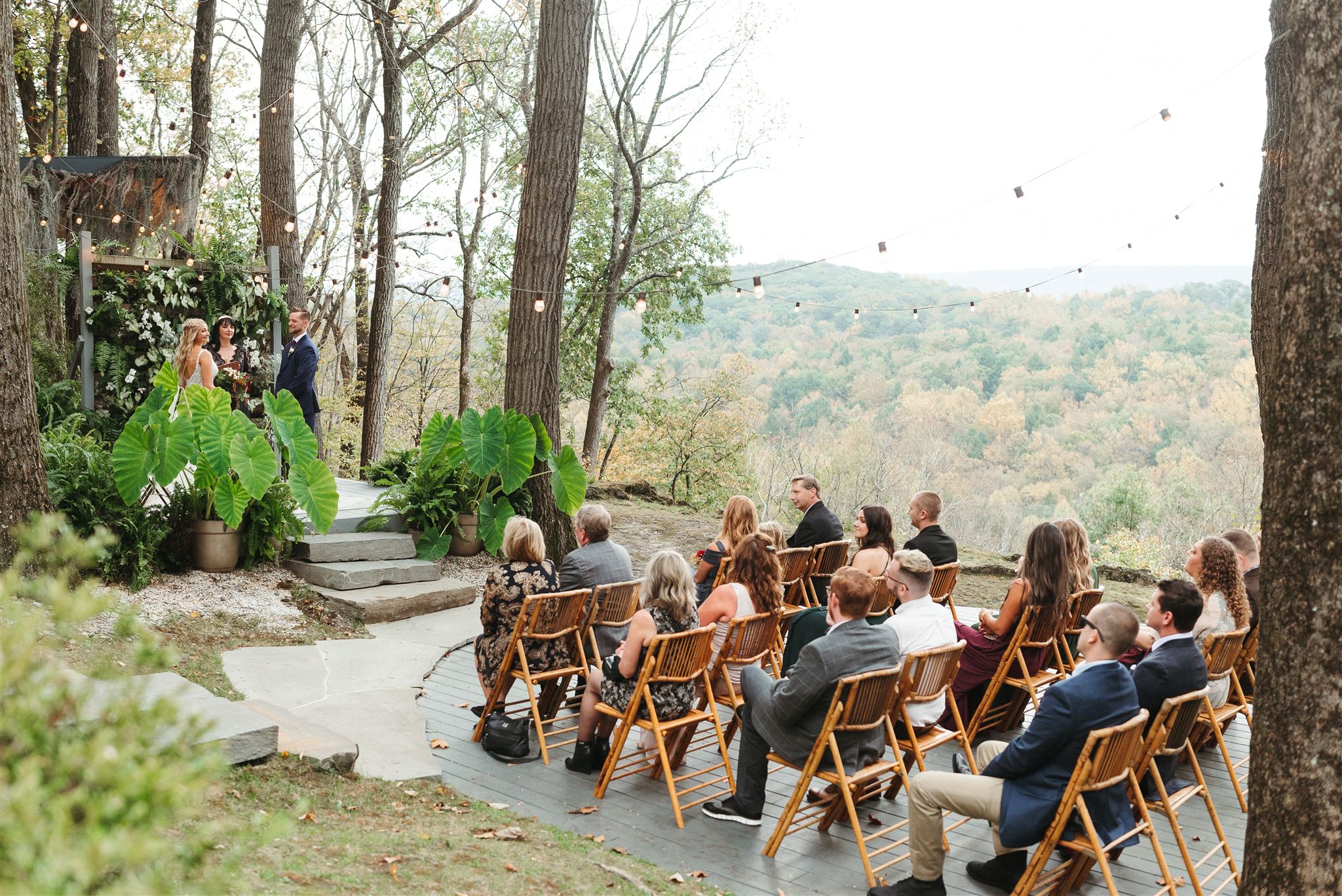 Shot for Sarah Brookhart - How to Elope in Philadelphia 2022: Outdoor wedding ceremony with bride and groom at the wedding arch and about 20 guests sitting and looking on