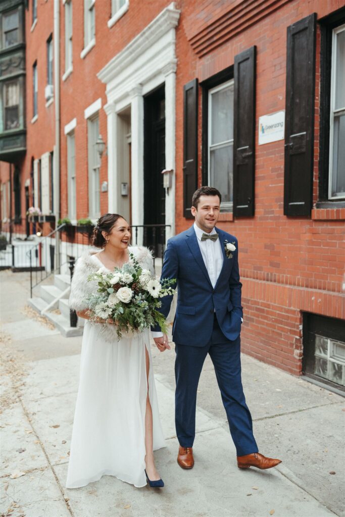 Shot for Jess Flynn - How to Elope in Philadelphia 2022: Couple holding hands and smiling as they walk around during their wedding photoshoot