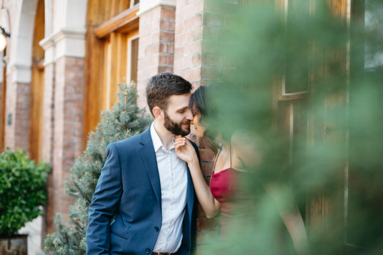 Couple lean in for a kiss in front of a vintage building, taken by modern wedding photographer Jason Moody