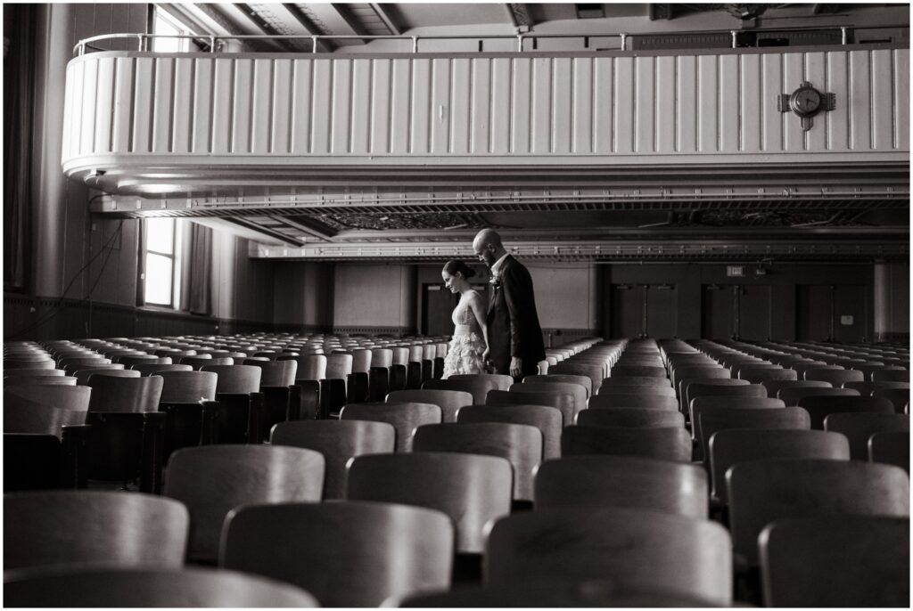 A bride and groom walk through the BOK Building auditorium before their Irwin's wedding.