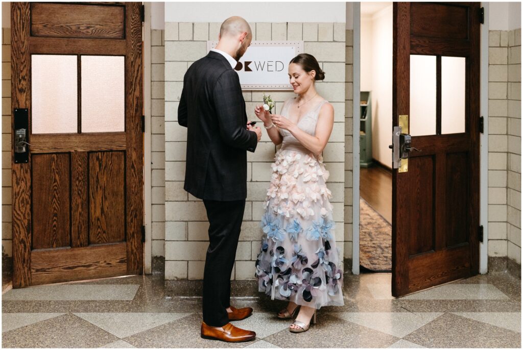 A bride and groom stand in the hallway of the BOK Building.