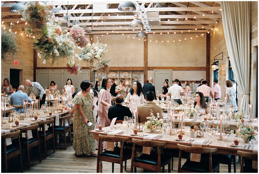 Wedding guests enter a Terrain wedding reception decorated with pink floral installations.