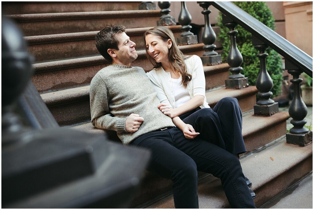 Jess and Matt cuddle on the steps of a brownstone in their New York City engagement photos.