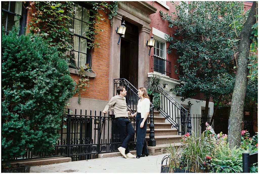 Jess and Matt stand outside a vine-covered brick building for their New York City engagement photos on film.