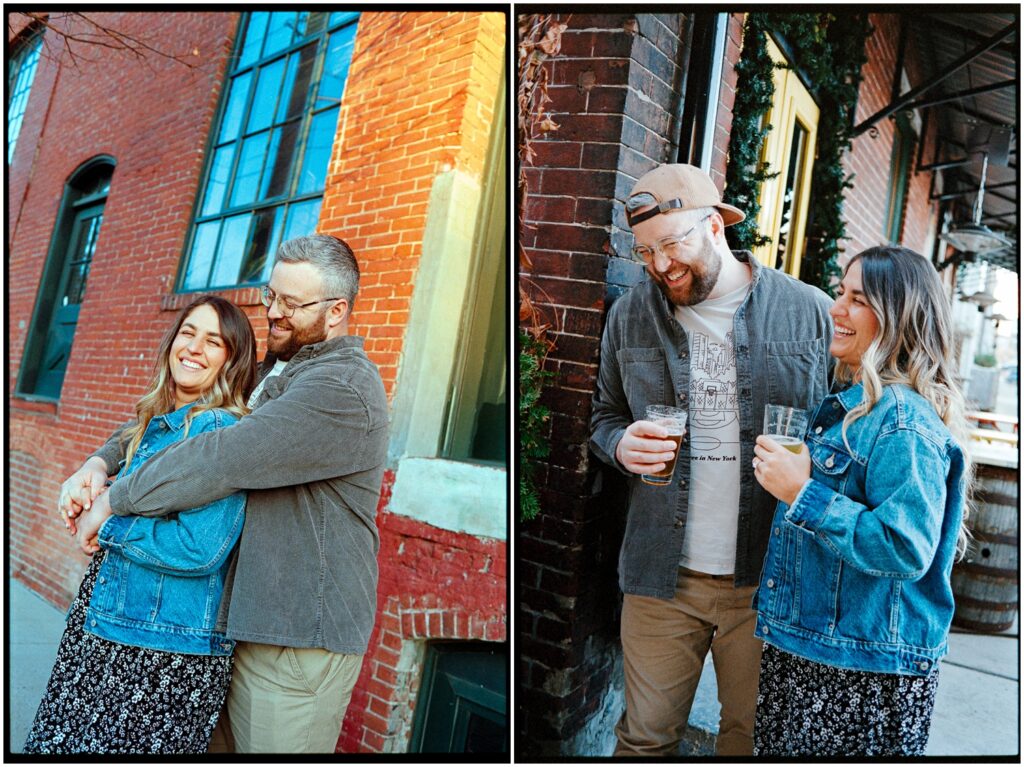 A couple drinks beer and laughs on a sidewalk in a philadelphia engagement session.