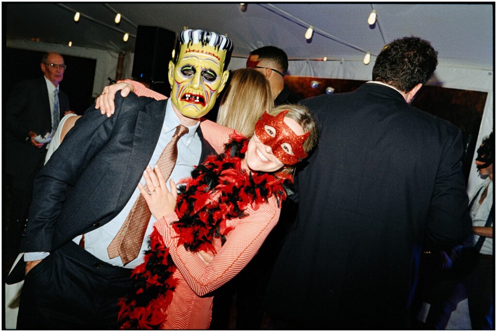 Wedding guests in masks pose on the dance floor.