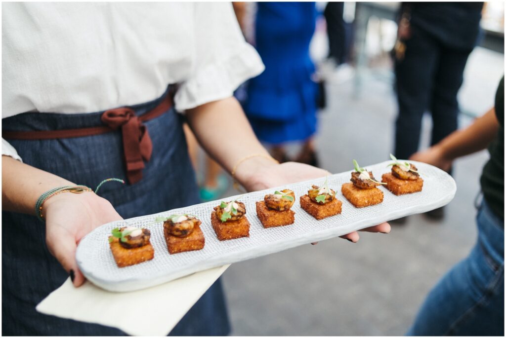 A server carries a tray of vegetarian appetizers.
