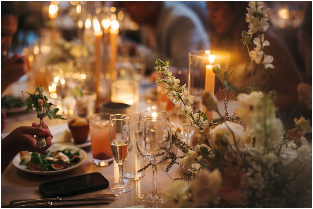 Guests eat salads at a candlelit table at a Terrain wedding.