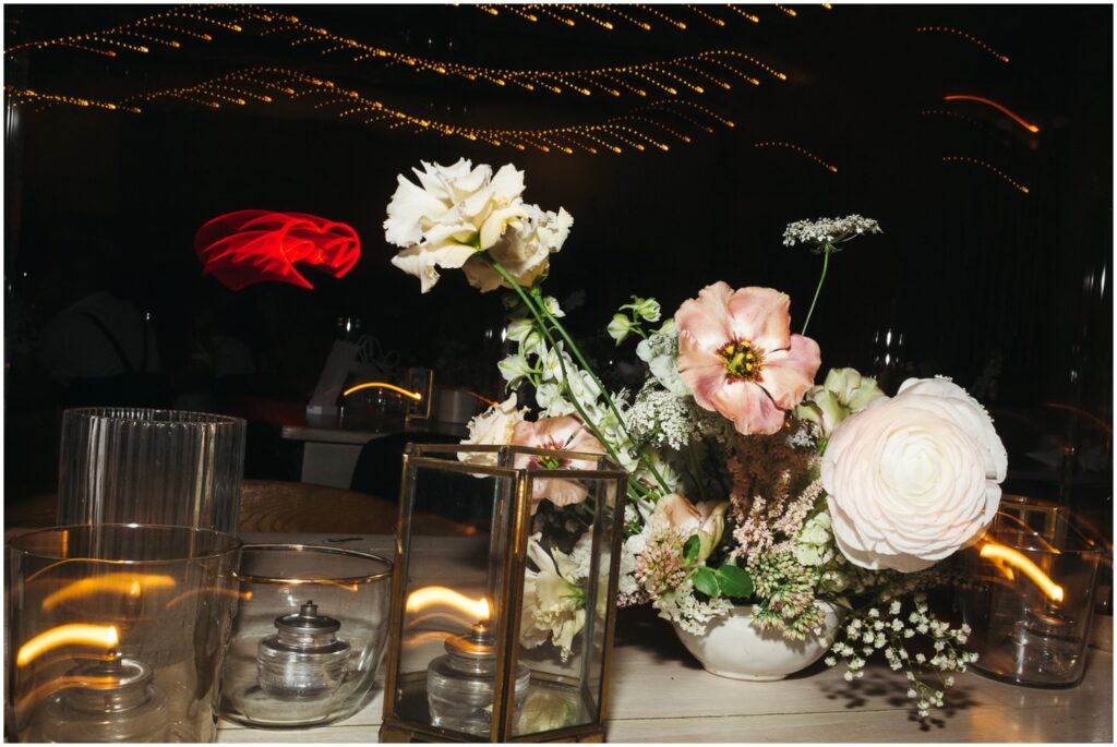 Lights blur behind a floral arrangement at a Terrain wedding reception.