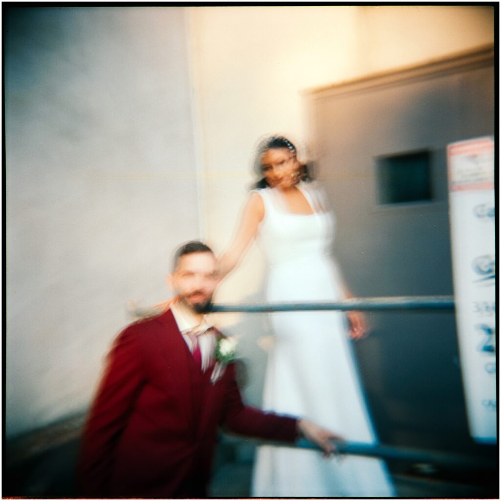 A blurred photo of a bride and groom posing on a staircase