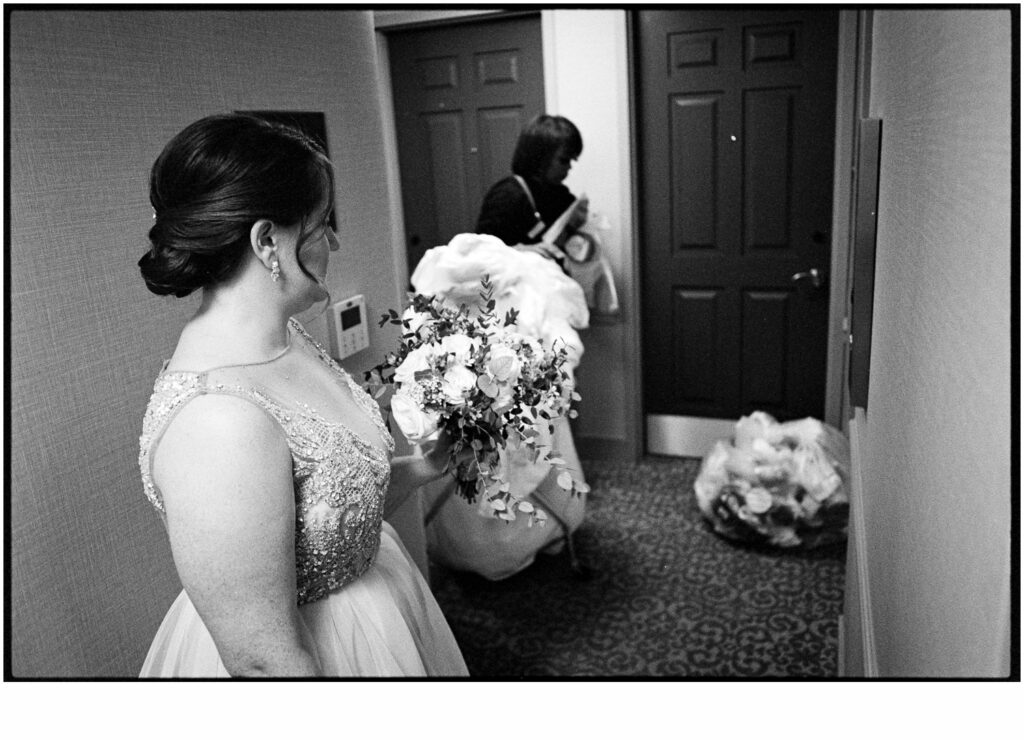 A bride carries a bouquet of white flowers through a Philadelphia hotel.
