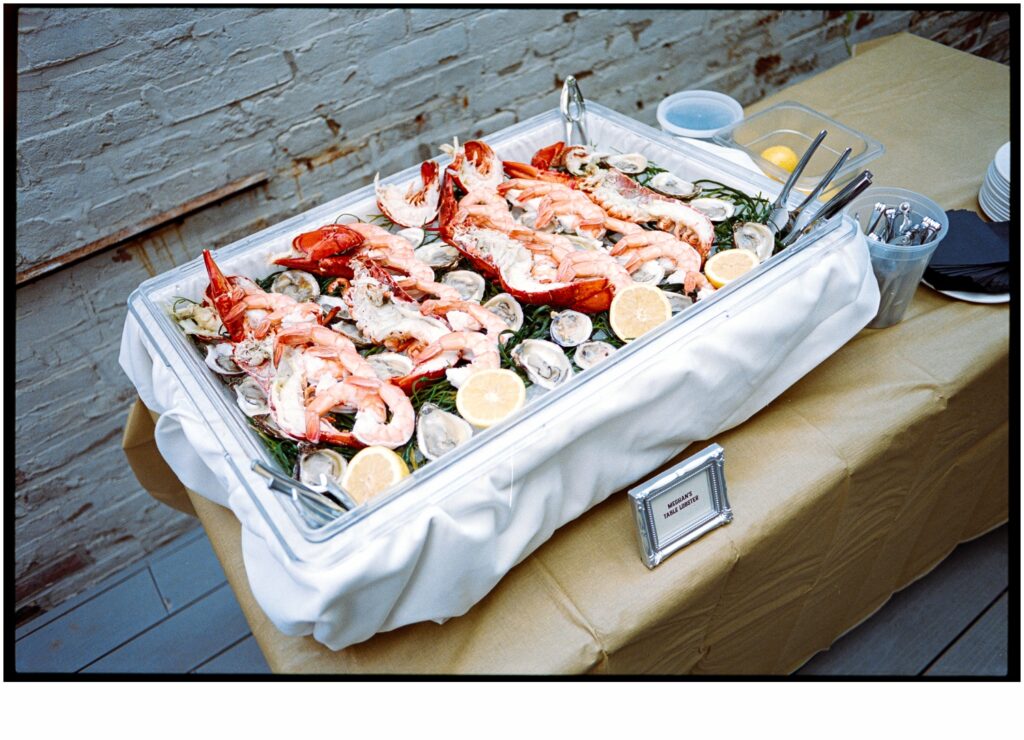 A platter of shrimp sits on a table for a wedding cocktail hour.