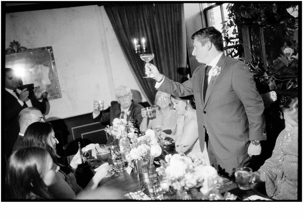 A guest raises a wine glass for a wedding toast.