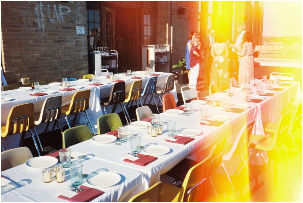 Two long tables are set for a wedding reception at a rooftop wedding venue in Philadelphia.