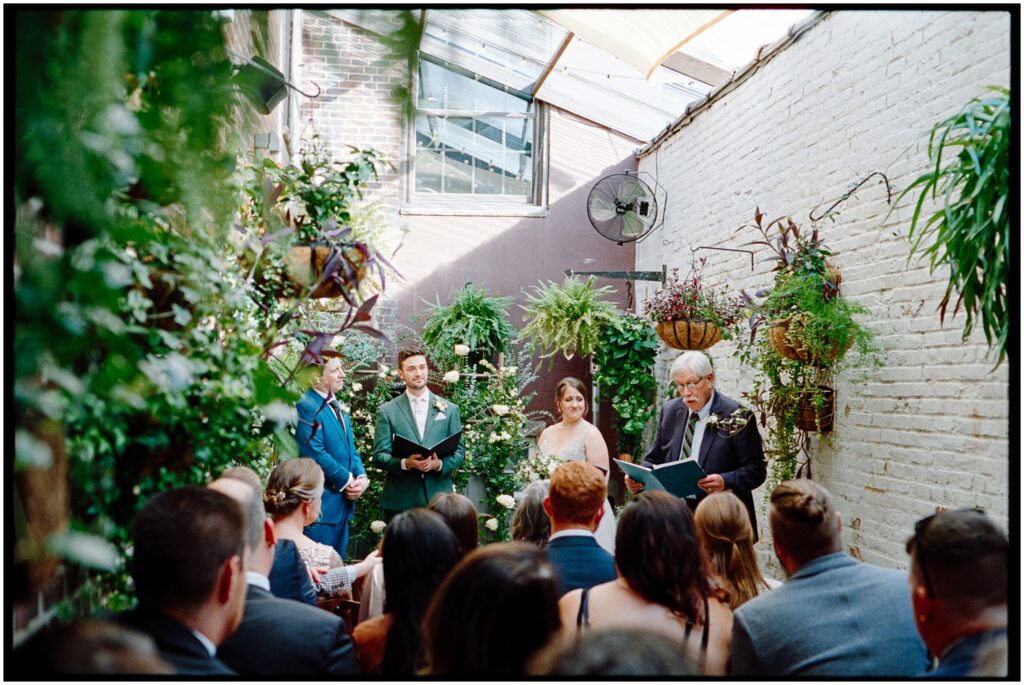 Wedding guests watch a wedding ceremony at Royal Boucherie, a small wedding venue in Philadelphia.