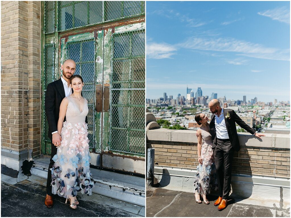 A bride and groom lean against a wall on a rooftop wedding venue with the Philadelphia skyline behind them.