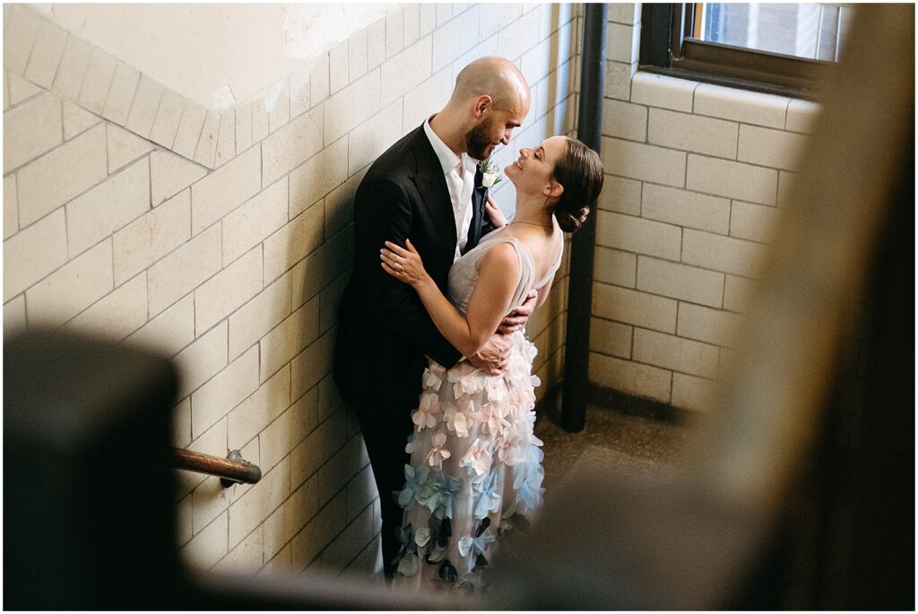 A couple embraces in a stairwell before their BOK Building wedding.