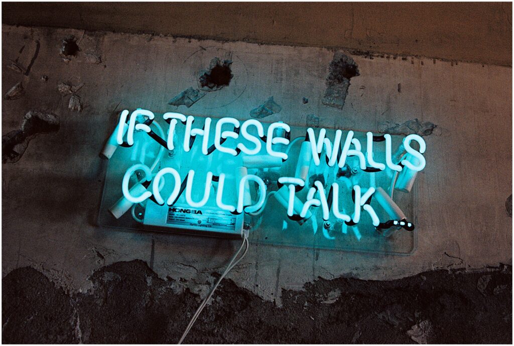 A blue neon sign in the BOK Building reads "if these walls could talk."
