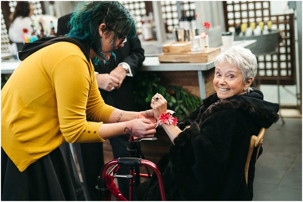 A guest ties a corsage to a family member's wrist.
