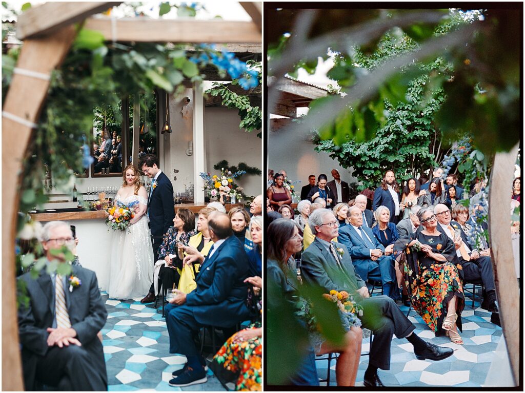 Wedding guests turn to watch a bride and groom walk up the aisle together in Suraya's courtyard.