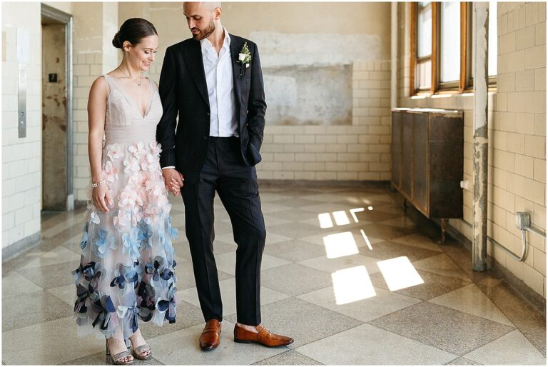 A bride and groom hold hands in the hallway of the BOK Building.