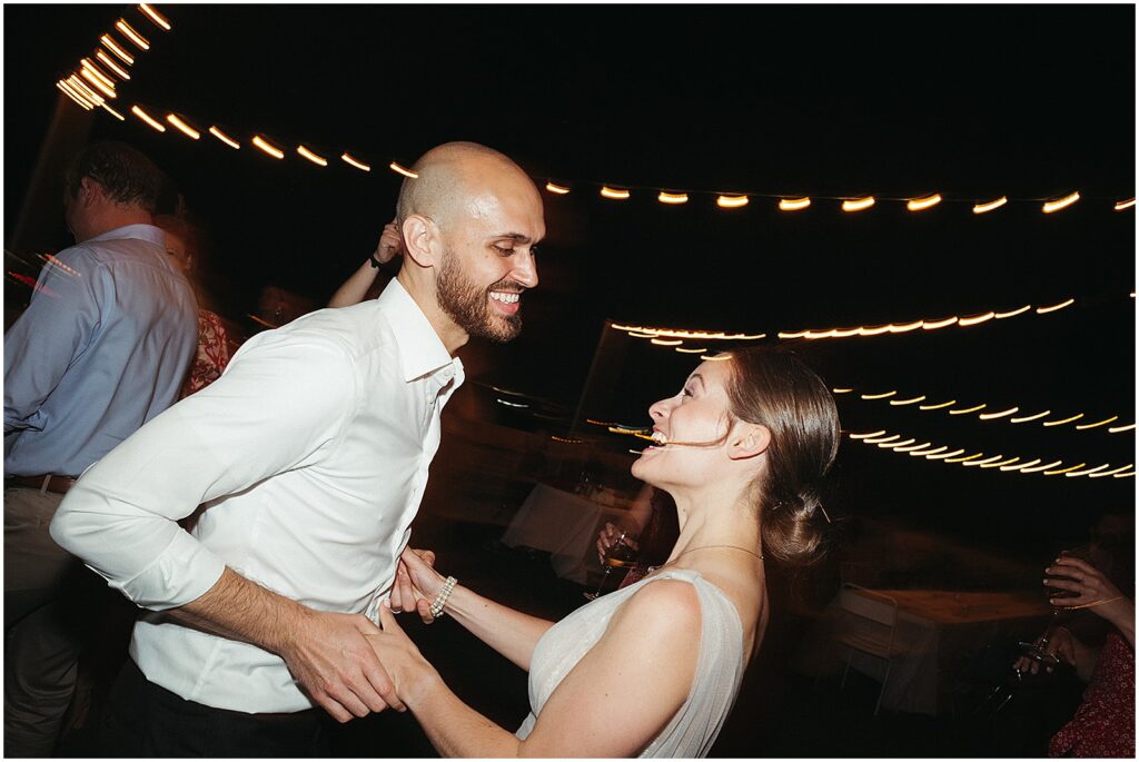A bride and groom dance together under strings of lights on the rooftop of the BOK Building.