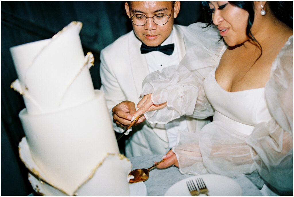 A bride lifts a slice from a creative wedding cake at Terrain Philadelphia.