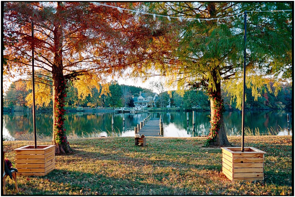 Orange and yellow-leafed trees line a lake on the afternoon of a Philadelphia wedding.