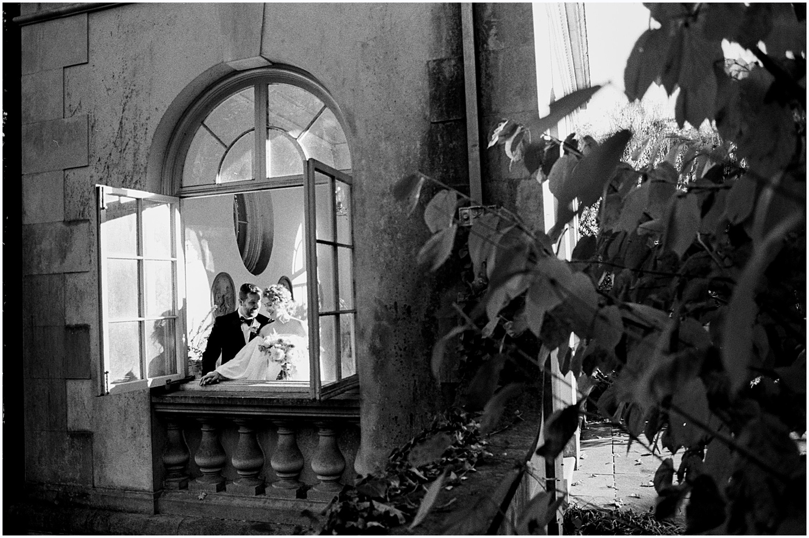 A Delaware wedding photographer photographs a bride and groom through the window of their wedding venue.