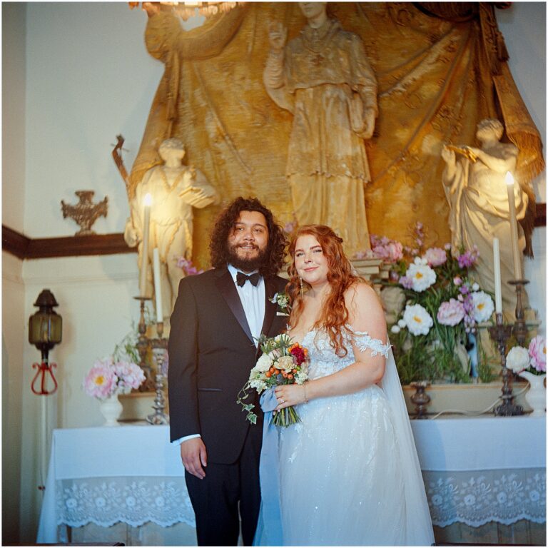 A bride and groom pose for destination wedding photography in an Italian chapel.