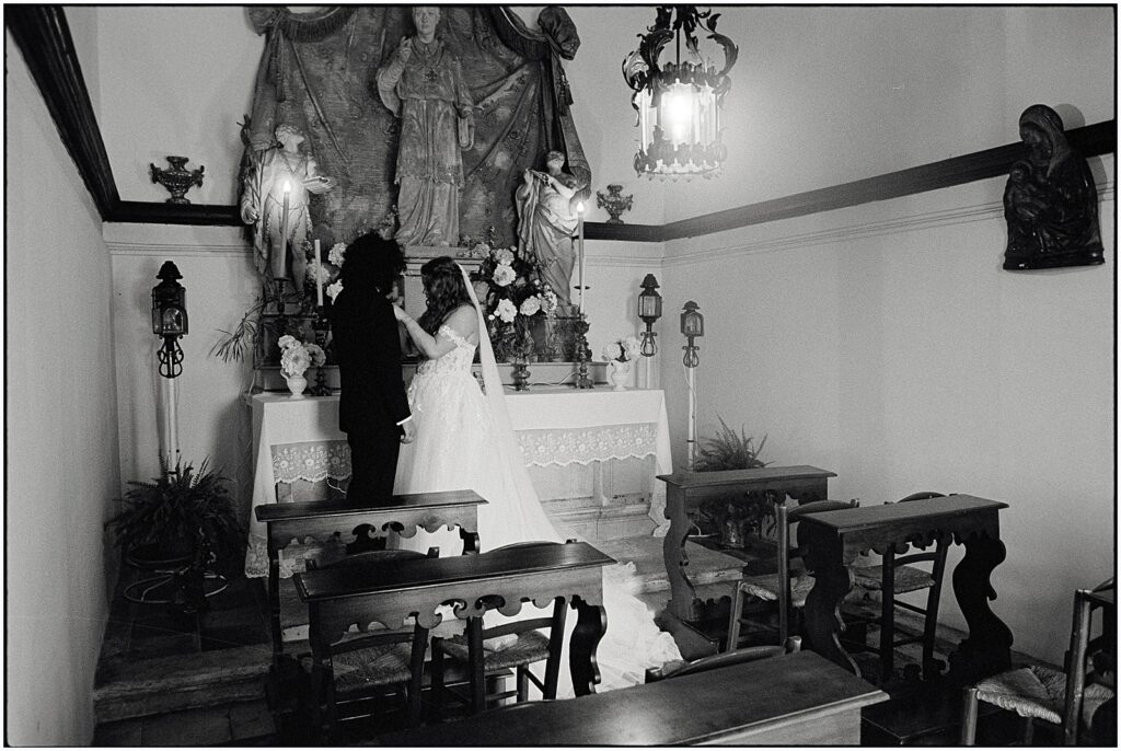A bride and groom hold hands in an Italian chapel at their destination wedding.