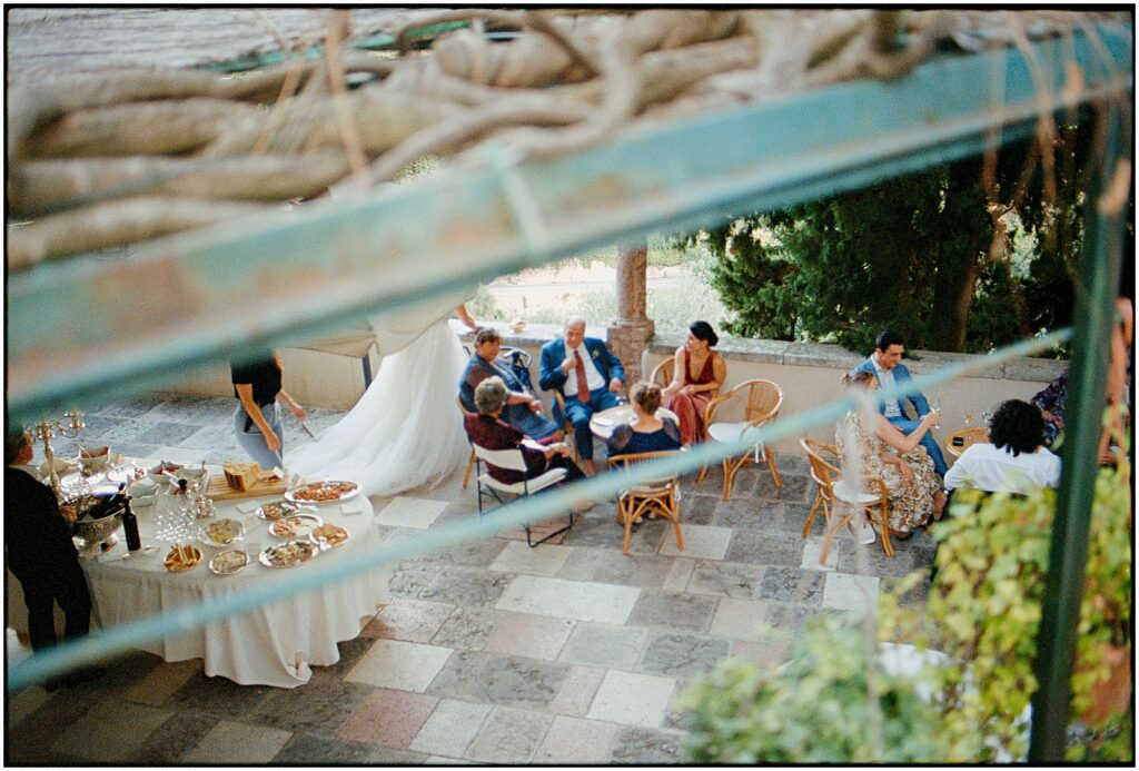 Destination wedding guests sit around a table on a terrace in Italy.