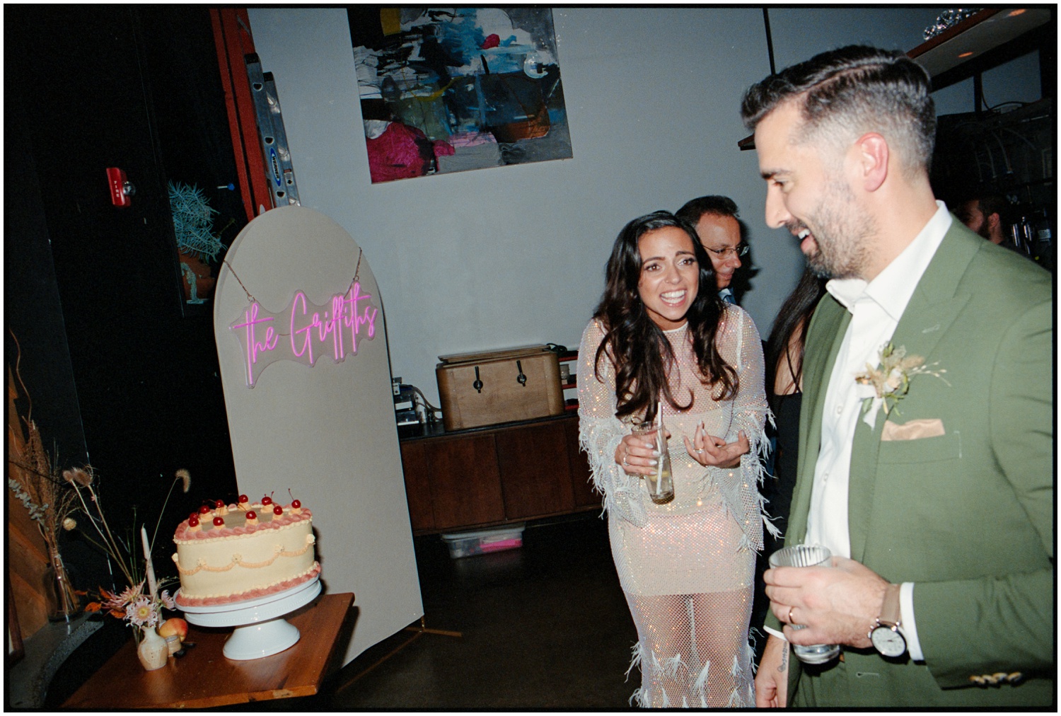 The bride and groom are flabergasted at their beautiful wedding cake made by their friend.