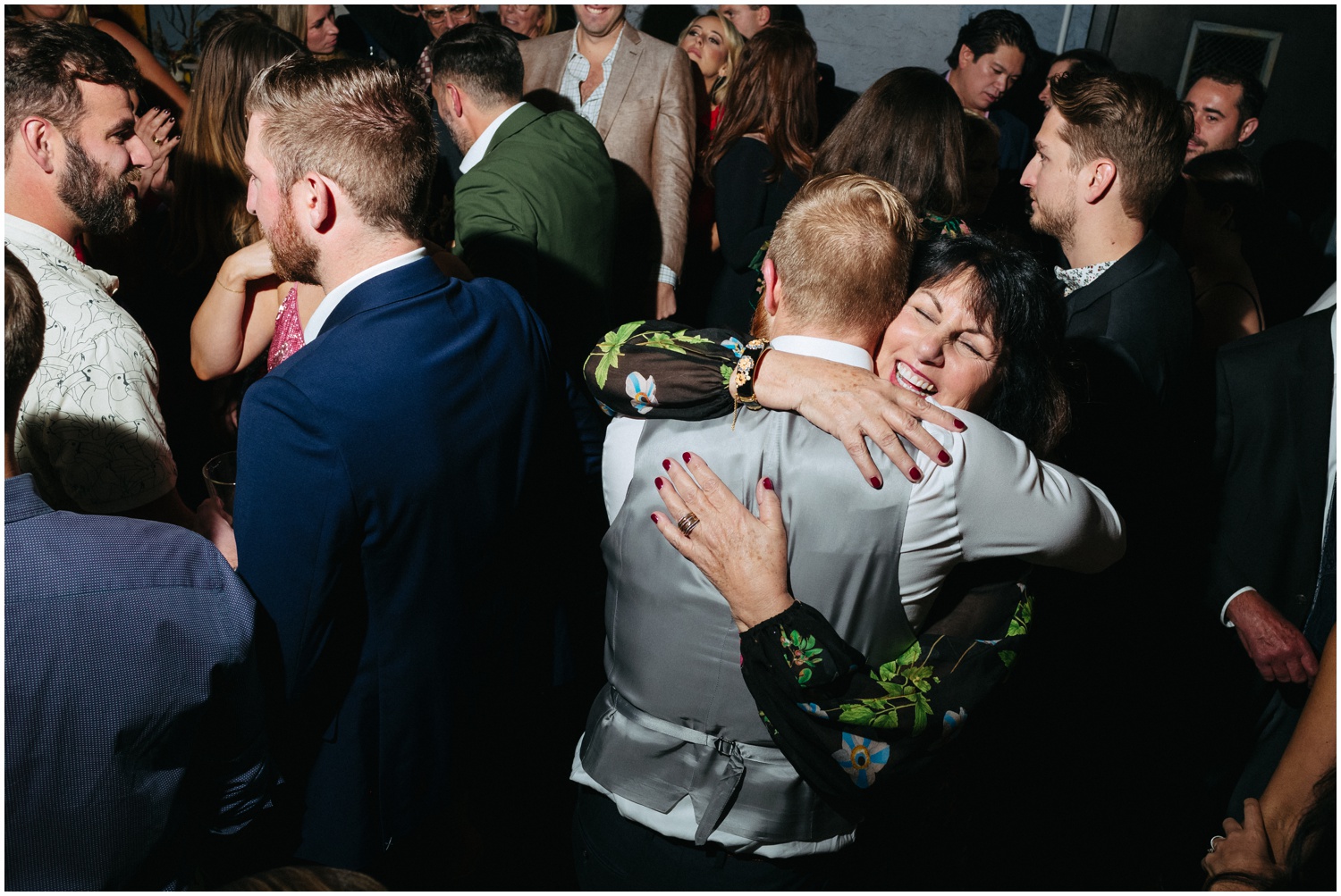 The groom's mom hugs a guest while they dance at a Philadelphia wedding